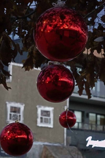 Jingle Bells Group 2023 Display - red balls hanging from street trees